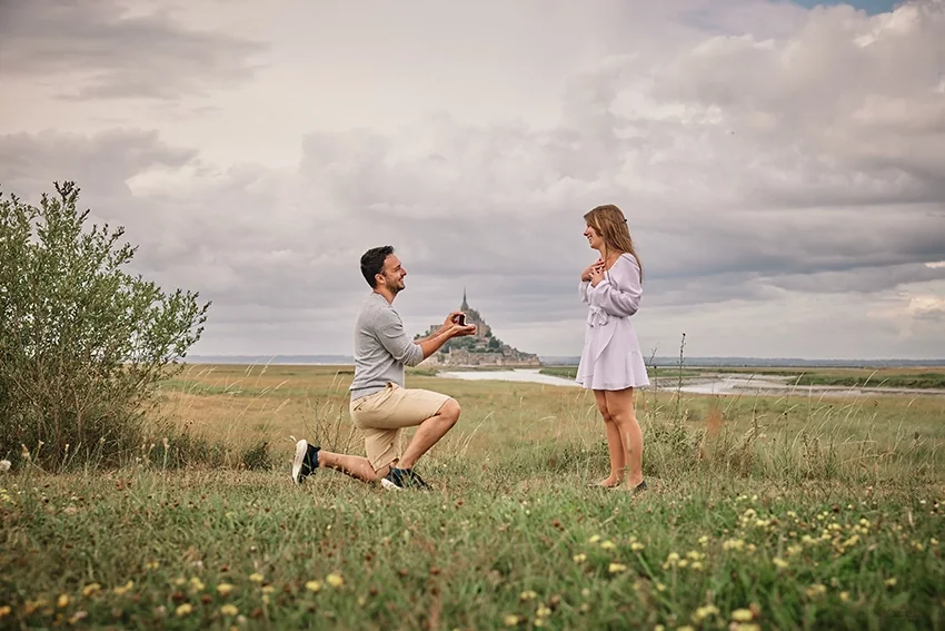 Demande en mariage à genoux dans la campagne, près du Mont Saint-Michel