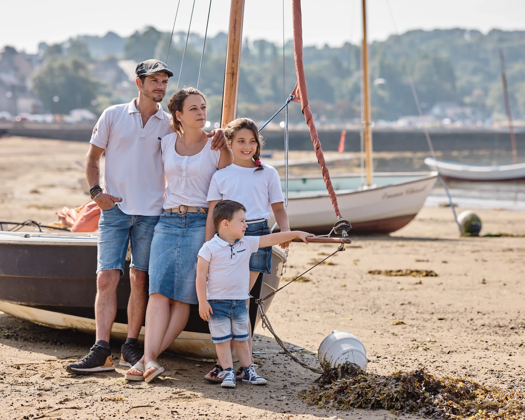 Photo de famille sur la plage entre les bateaux, en Bretagne