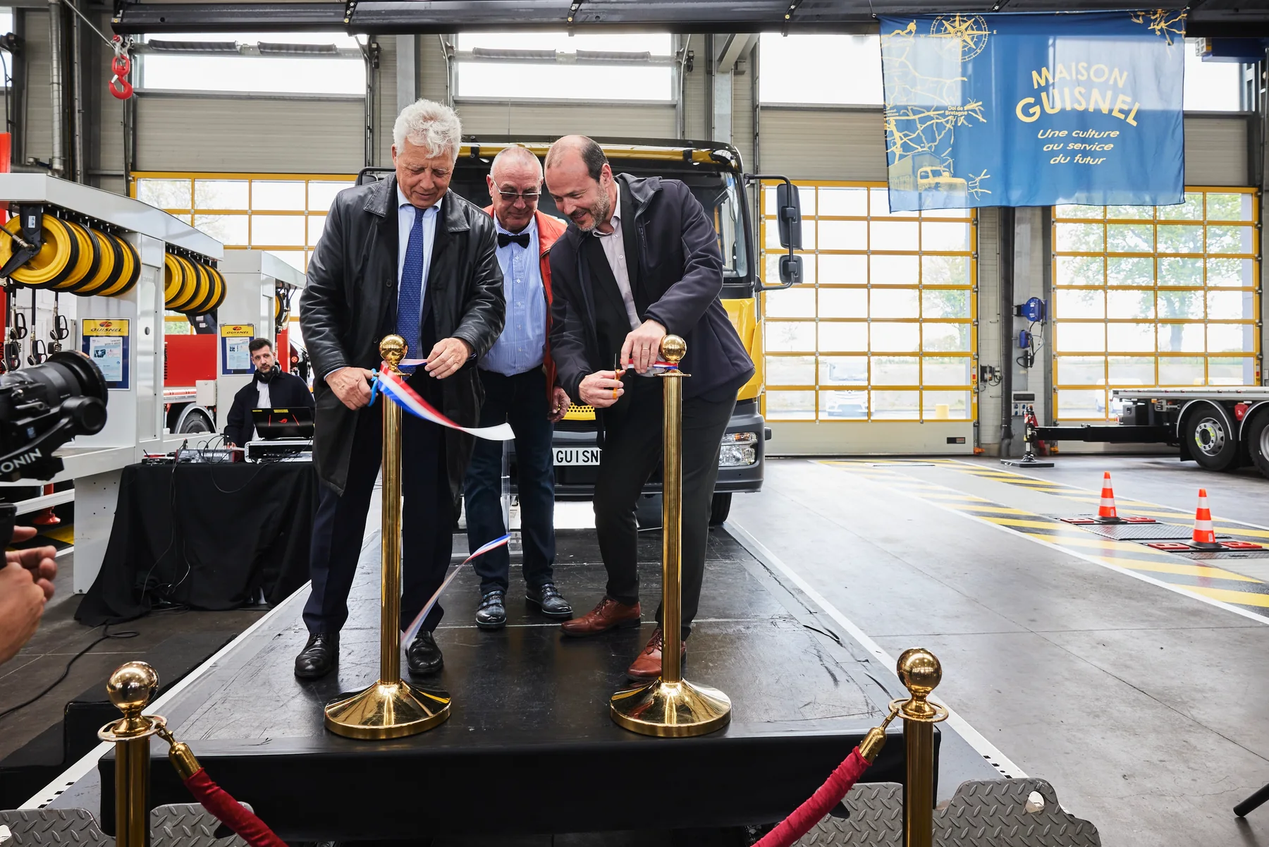 Coupe du ruban tricolore sur scène lors de l'inauguration du groupe Guisnel