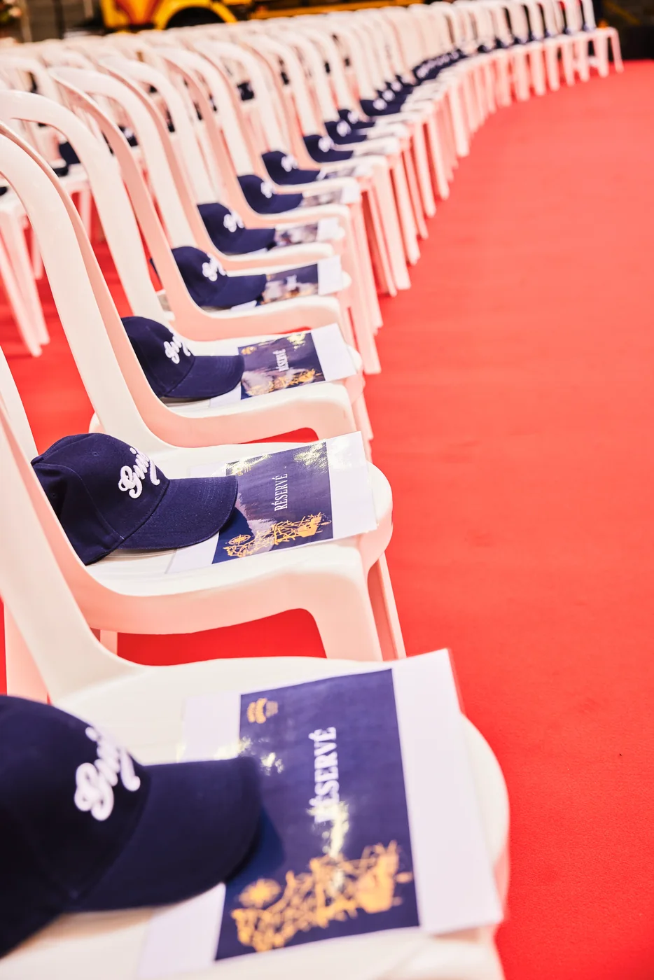 Chaises, casquettes et programmes disposés sur le tapis rouge avant la cérémonie Guisnel