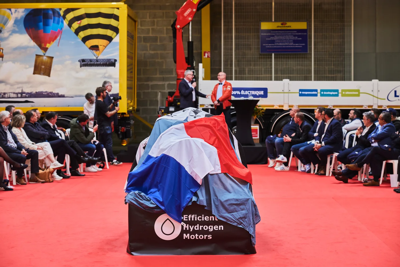 Moteur hydrogène Efficient Hydrogen Motors sous voile tricolore avant le dévoilement