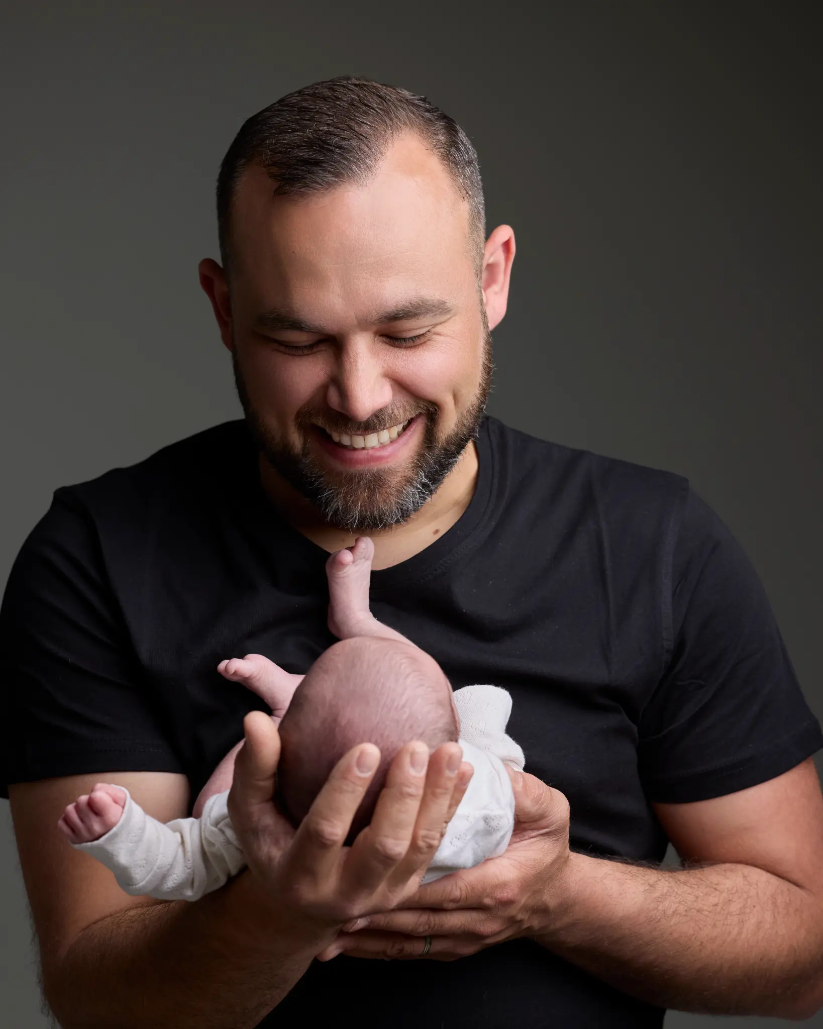 Portrait papa souriant tenant son nouveau-né au studio — Photographe naissance et famille Dol-de-Bretagne, Ille-et-Vilaine